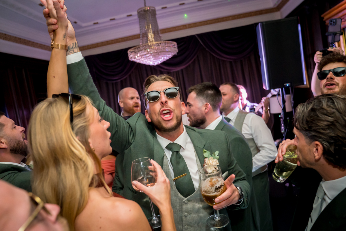 Wedding guests celebrating with drinks and dancing.