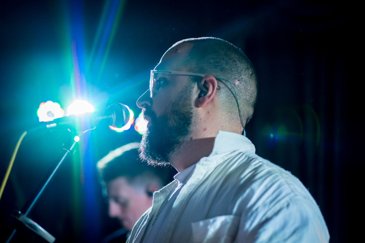 Bearded man singing on stage with microphone