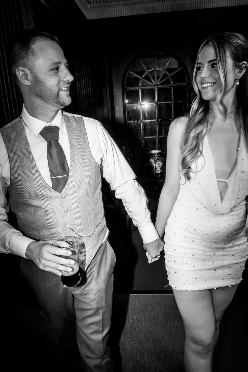 Couple holding hands, smiling at each other.