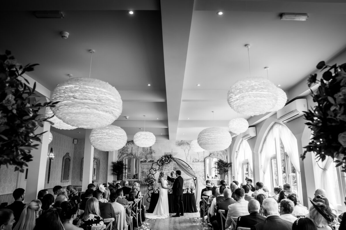 Indoor wedding ceremony with seated guests.
