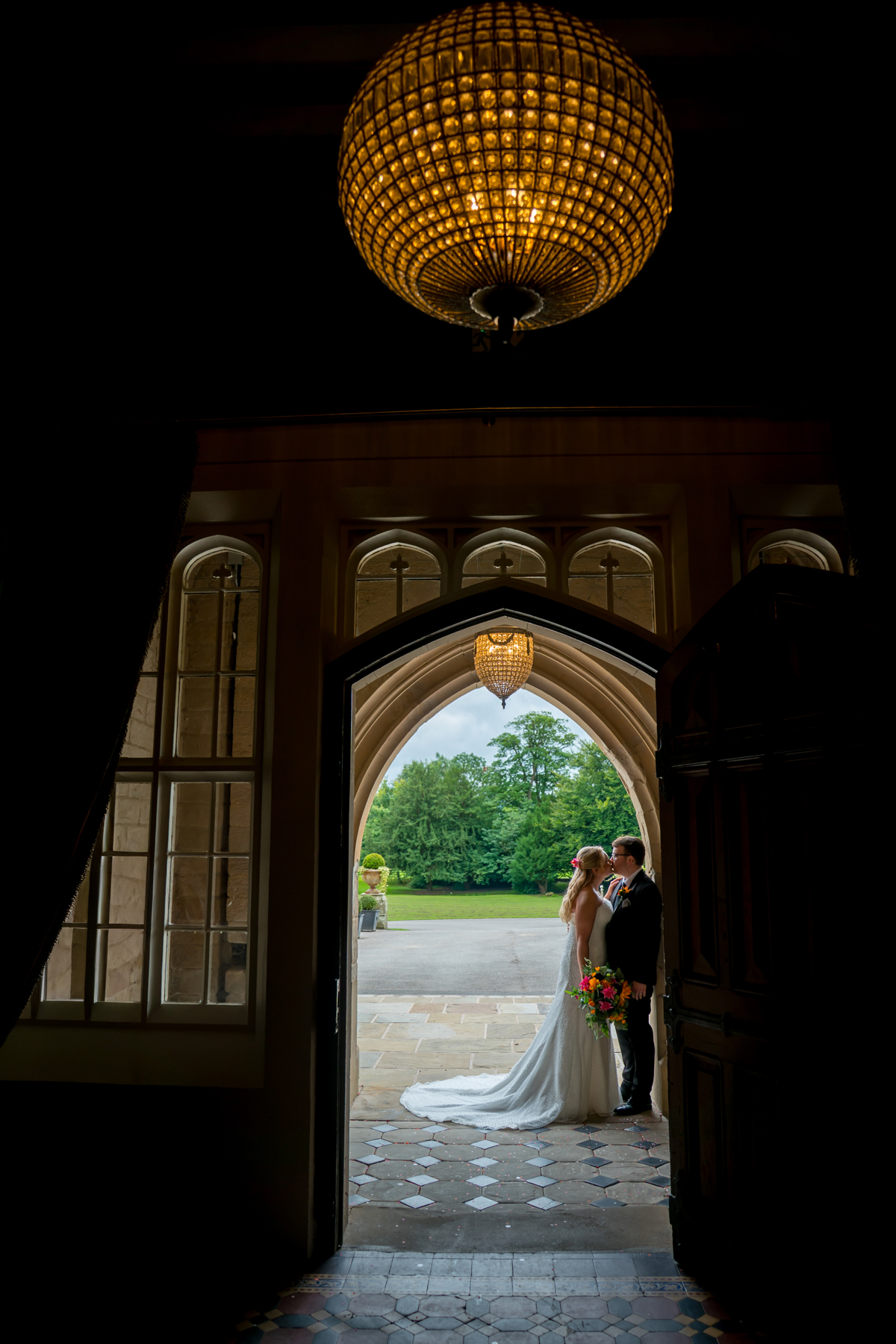 Bride and groom standing under an archway.