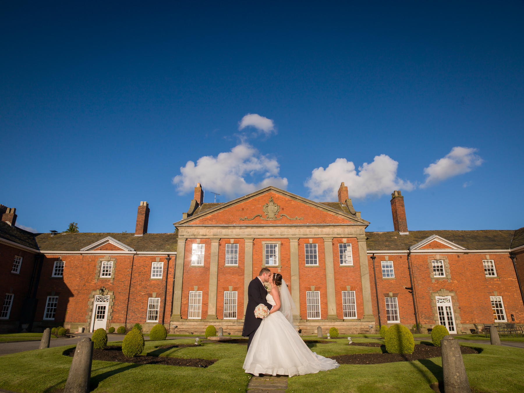 Bride and groom at picturesque historic manor house.
