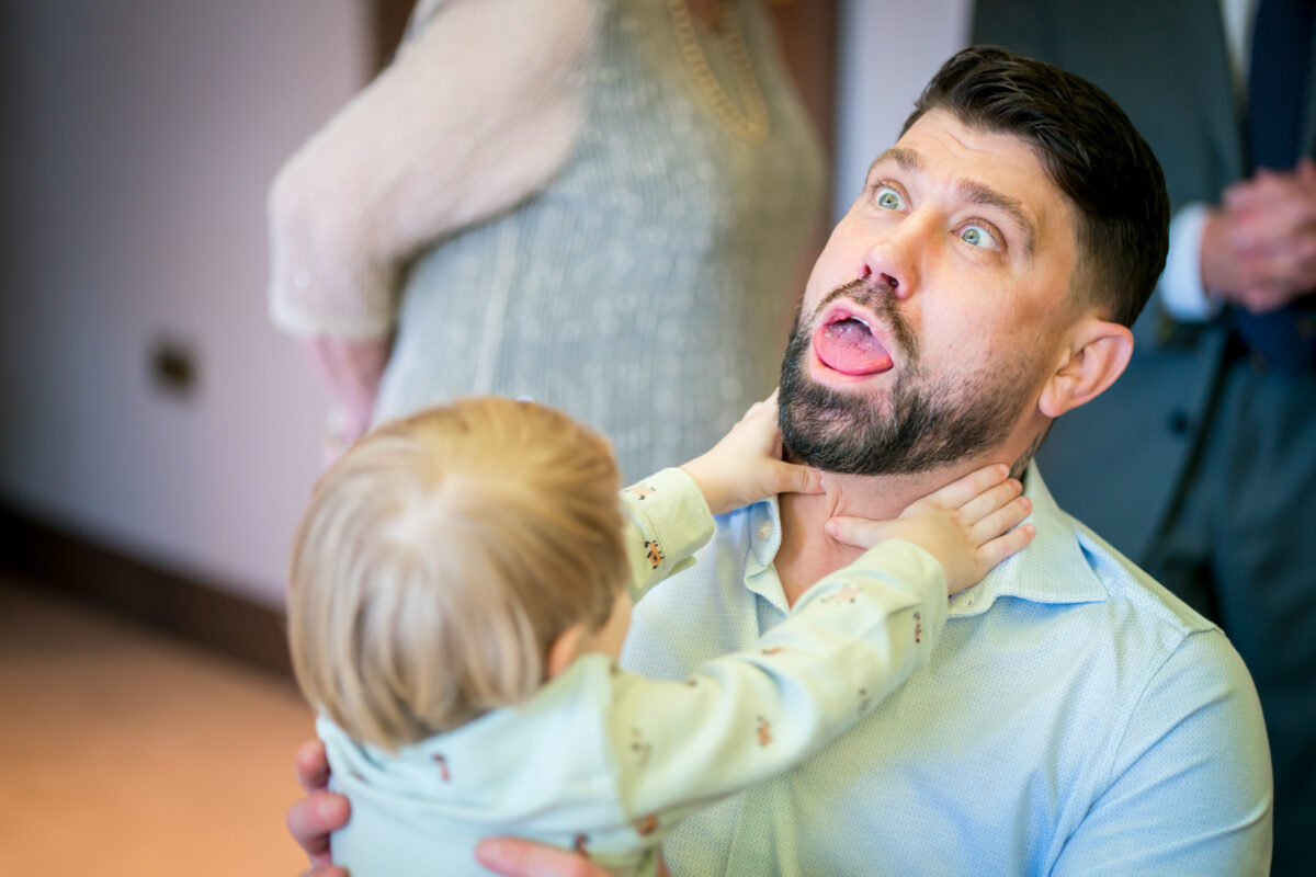 Man playfully interacting with child indoors
