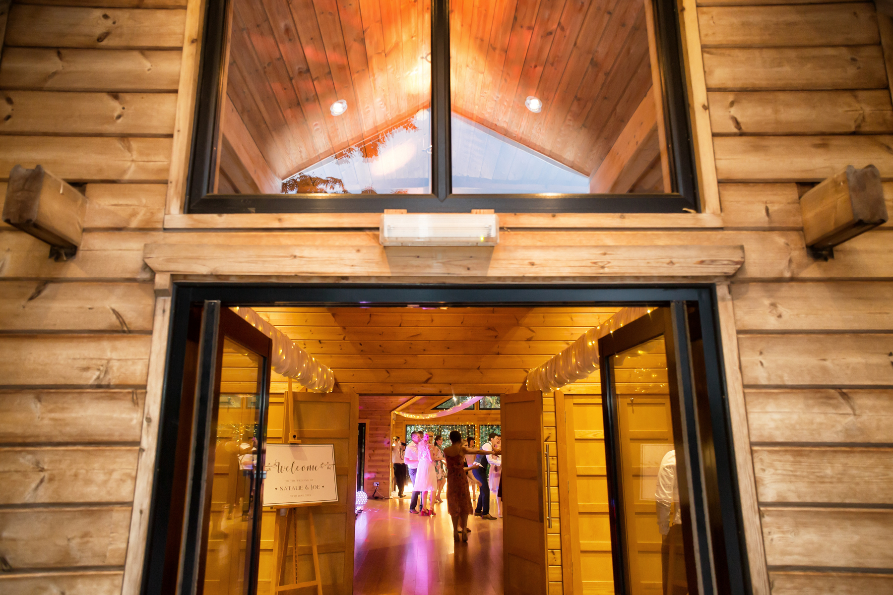 Wooden venue entrance with people dancing inside.