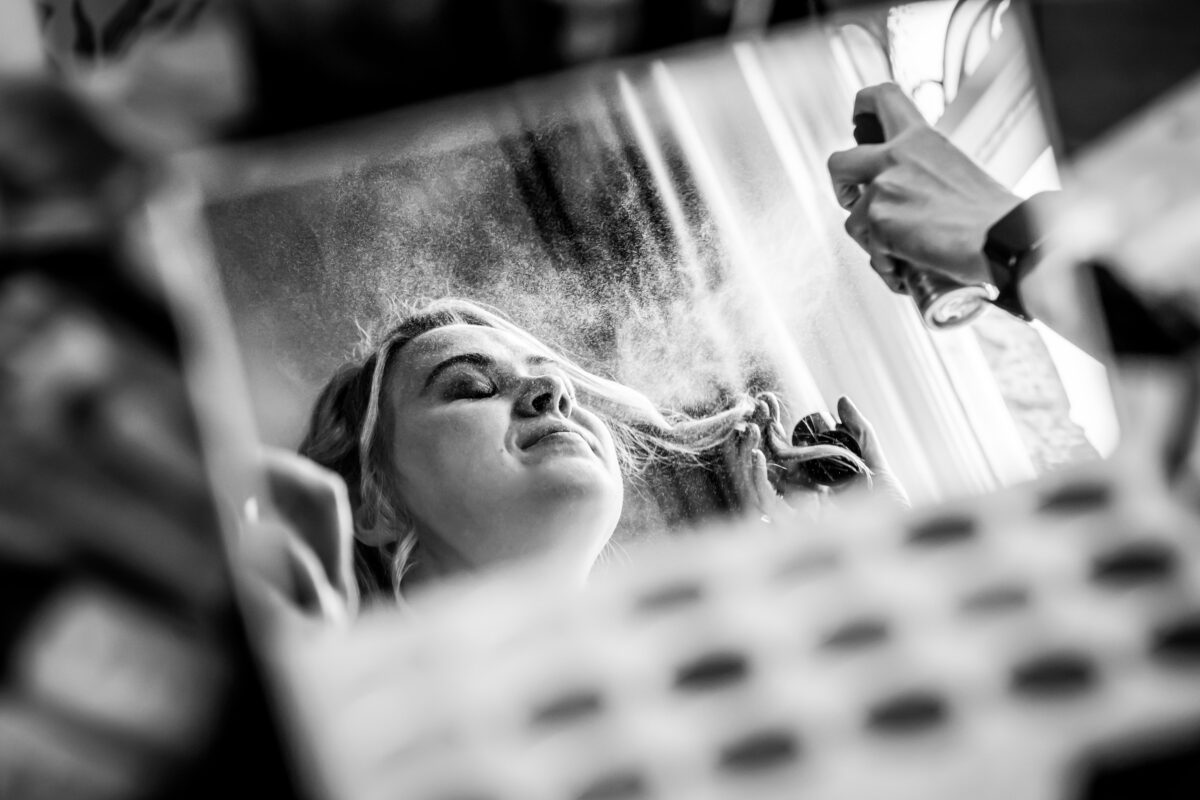 Woman having hair styled with hairspray.