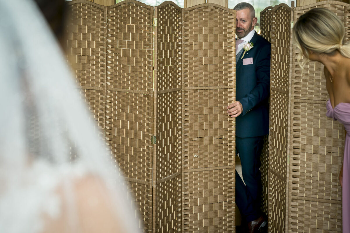 Man peeks from behind a divider