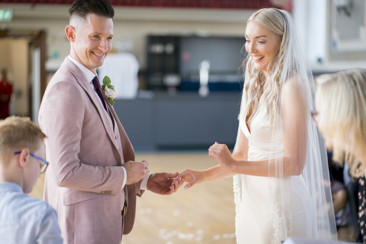 Bride and groom exchanging rings at wedding