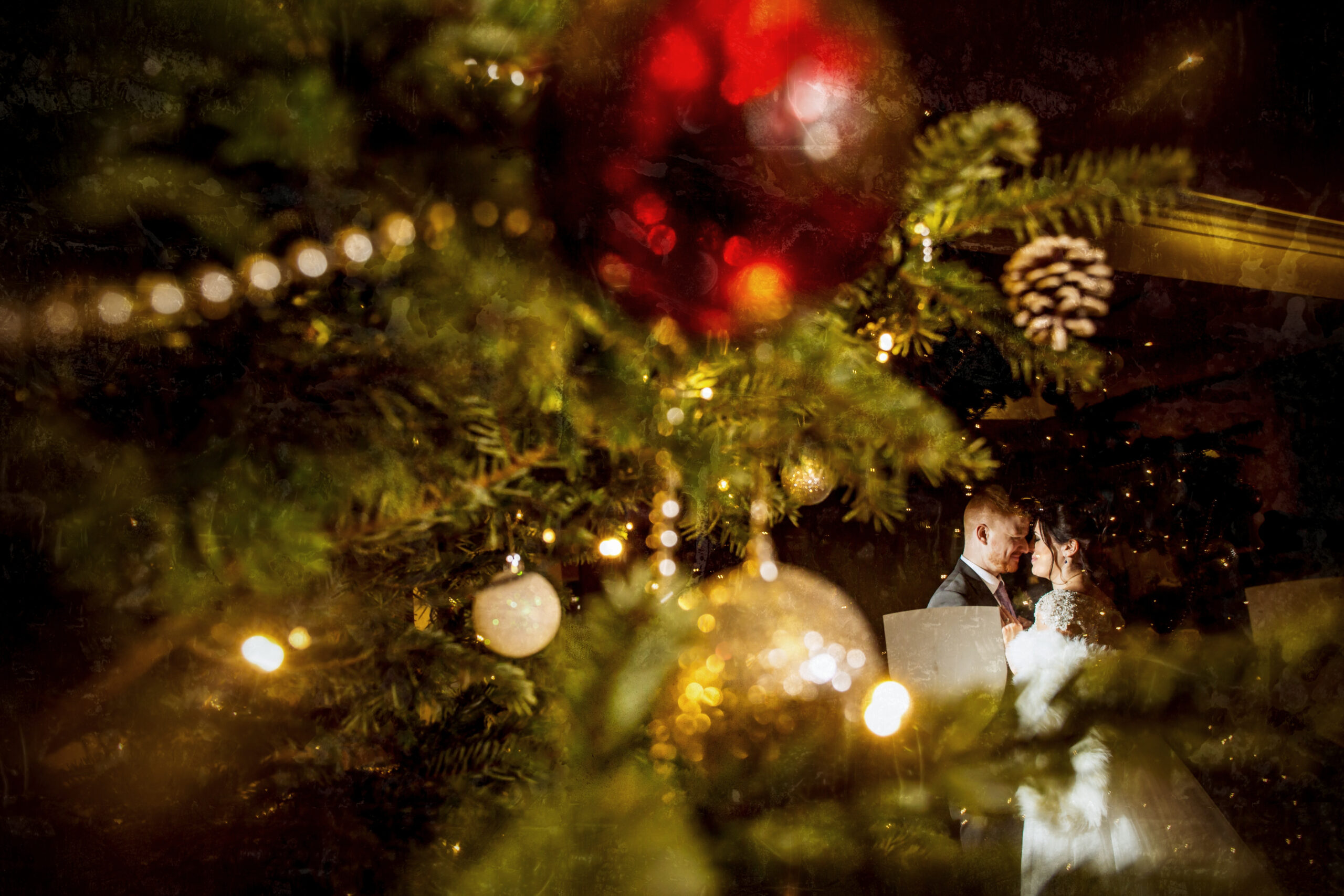 Wedding couple behind Christmas tree decorations
