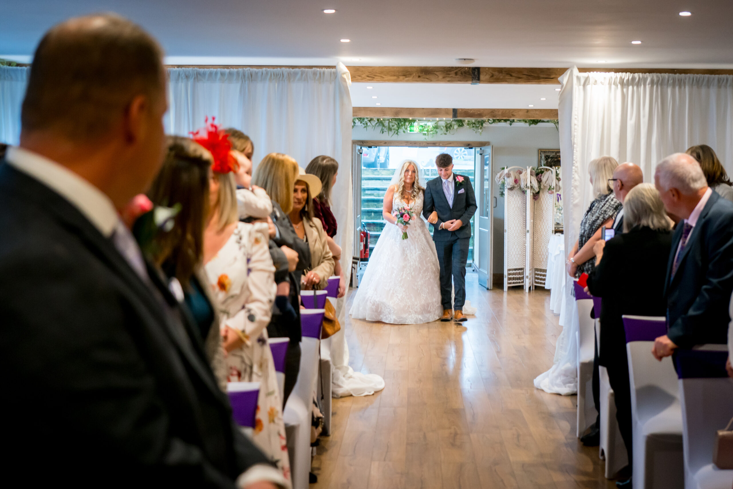 Bride walking down the aisle with a guest.