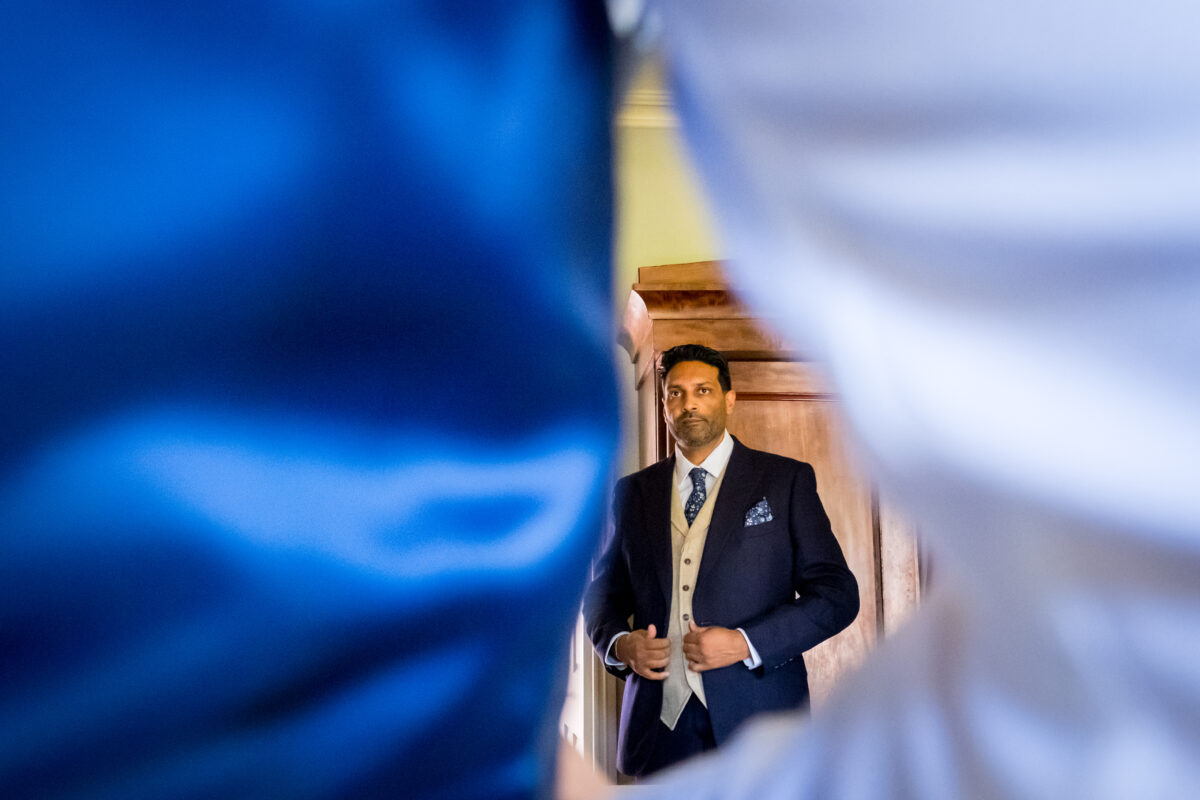 Man in suit adjusting waistcoat