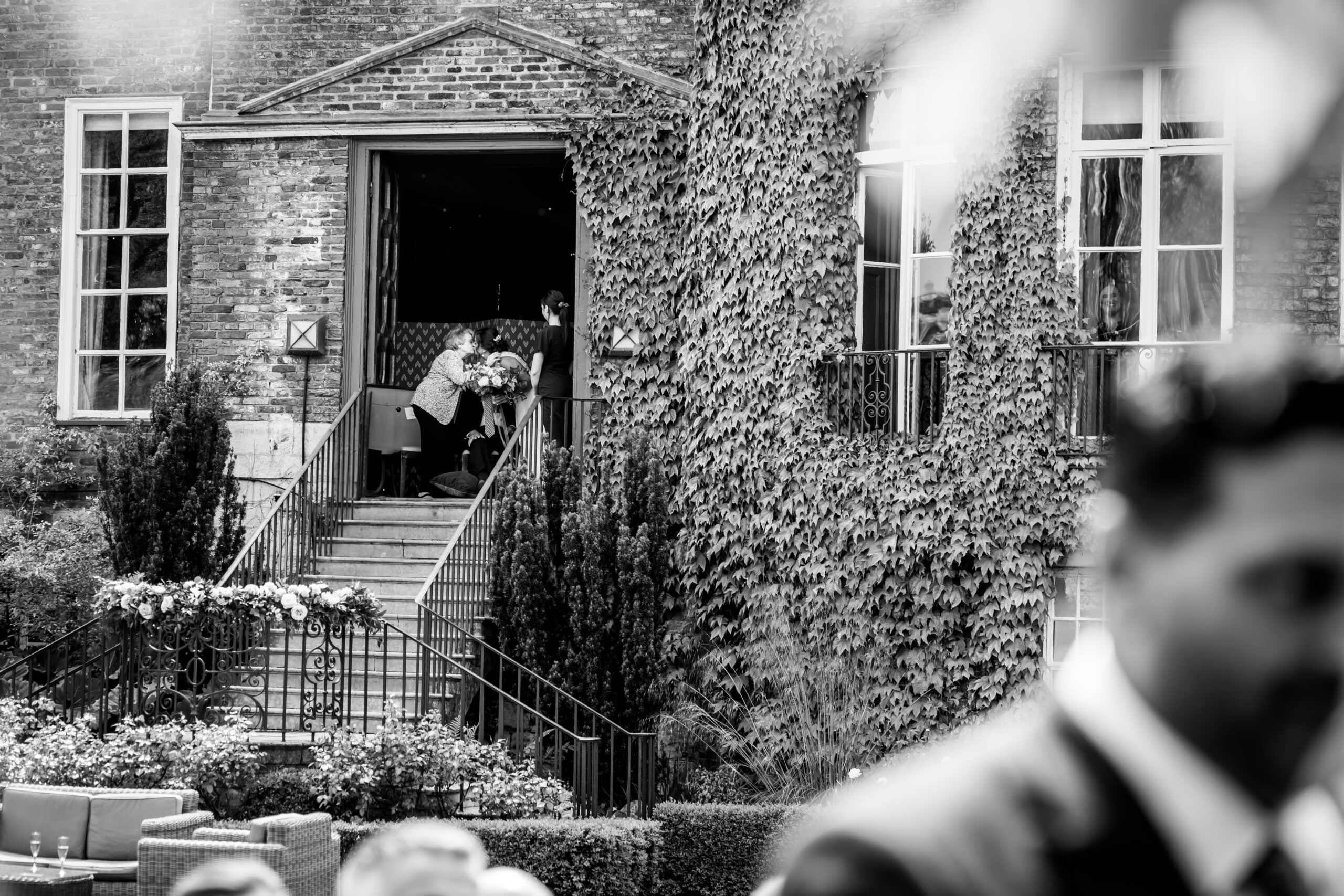 People at entrance of ivy-covered house