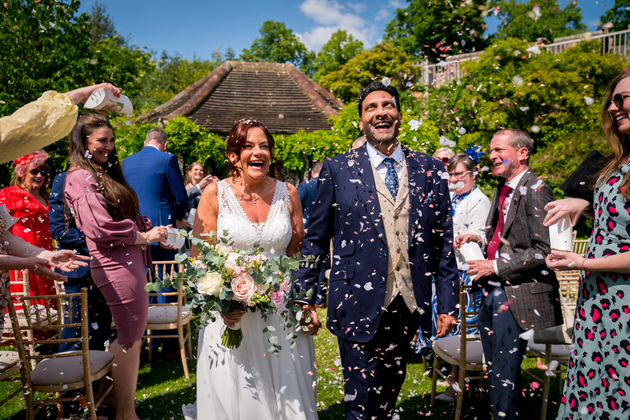 Cheerful bride and groom showered with confetti