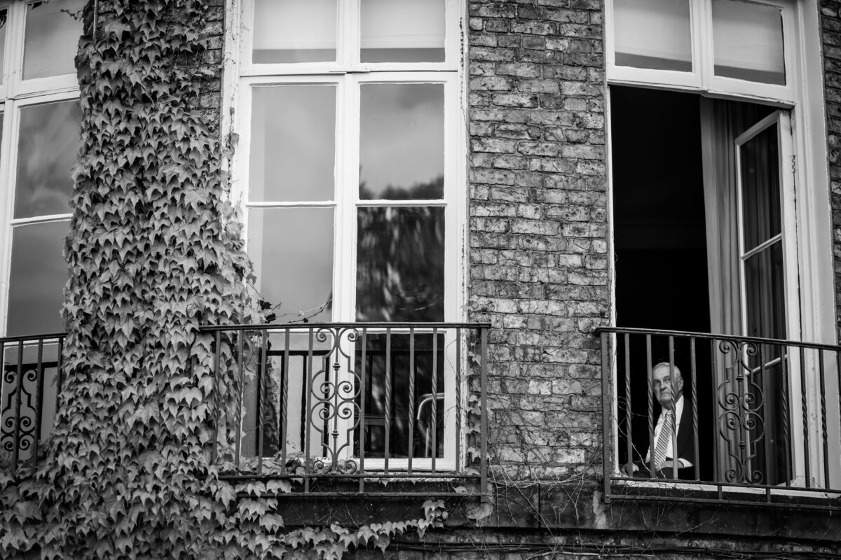 Man looking out window from balcony