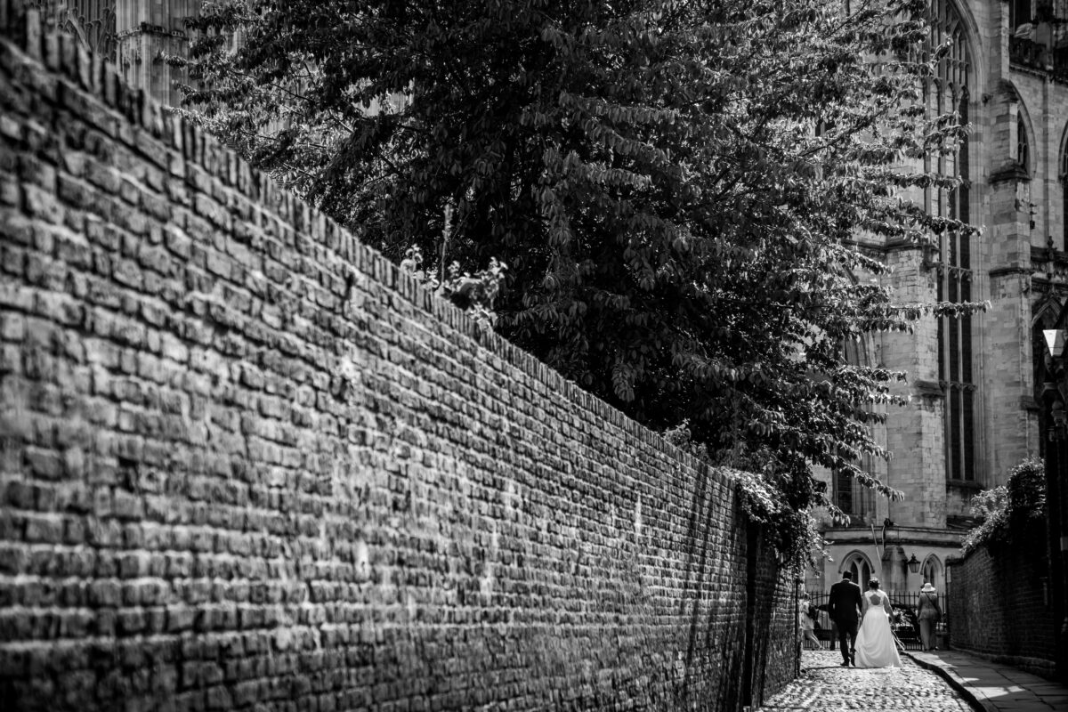 Bride and groom walking along cobbled street