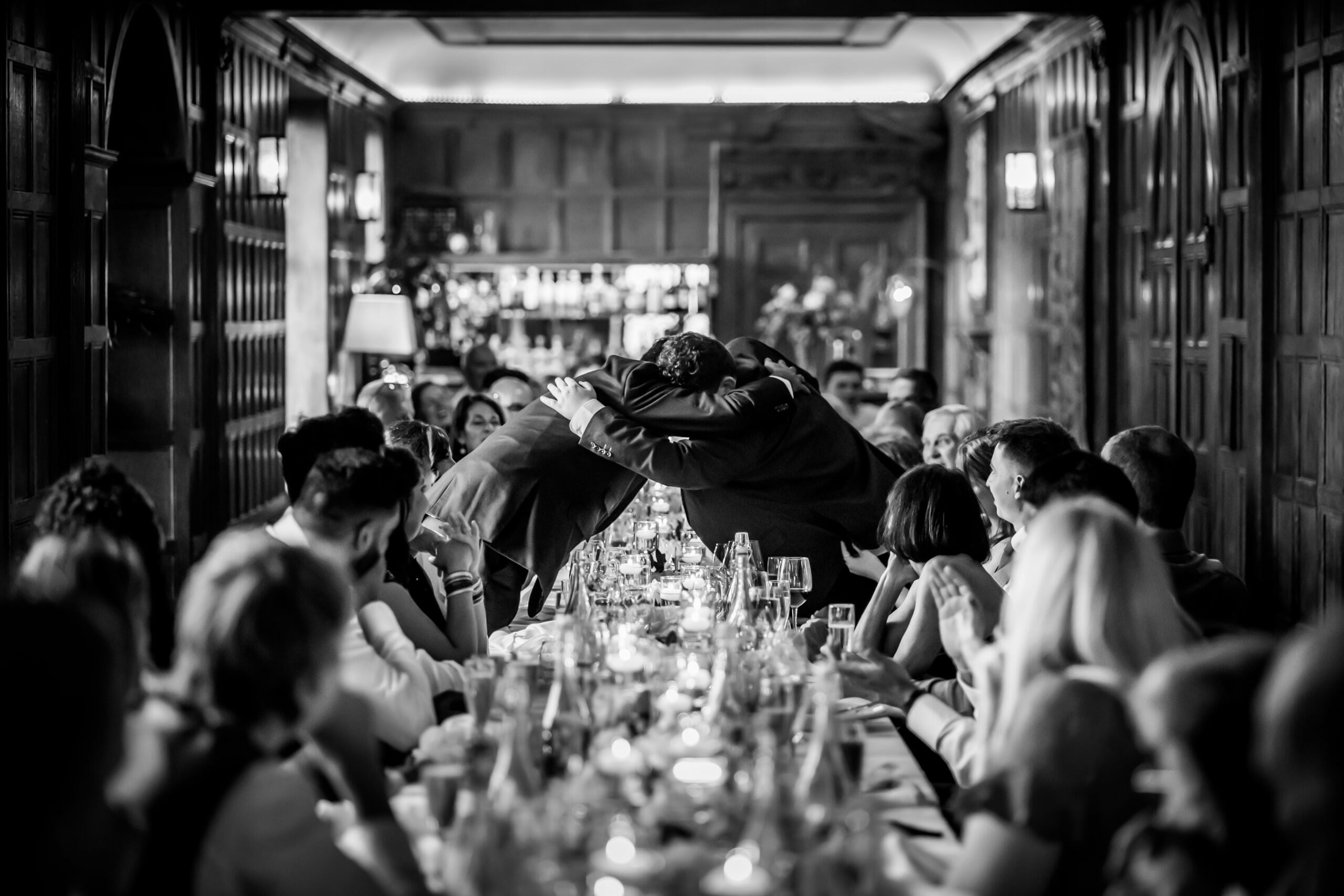 Black and white group hug at formal dinner.