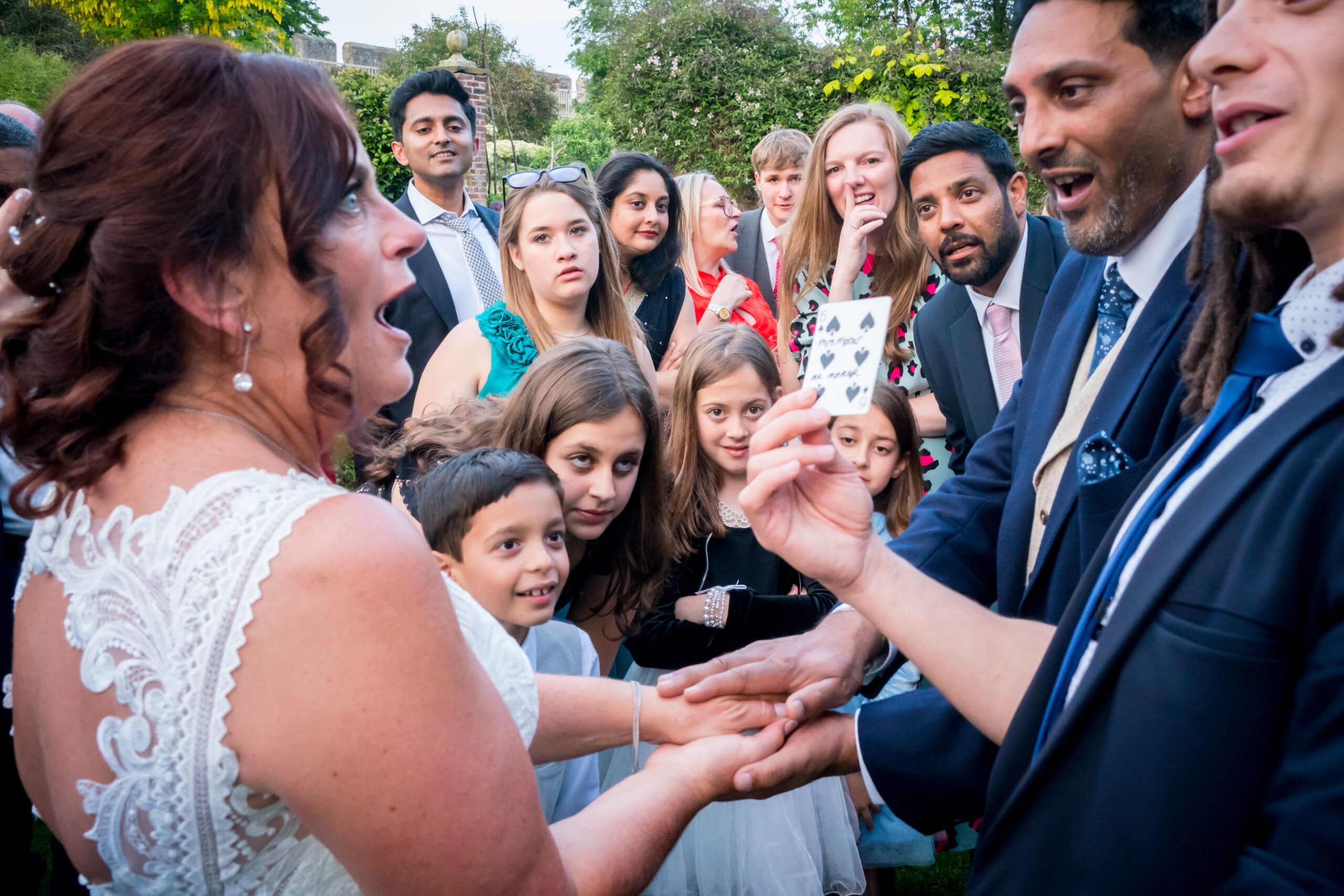Group amazed by magic trick at wedding