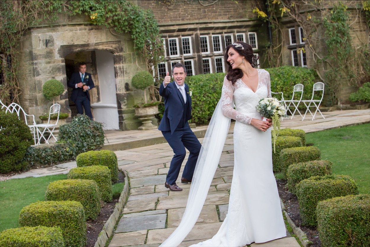 Bride smiling with groom giving a thumbs-up