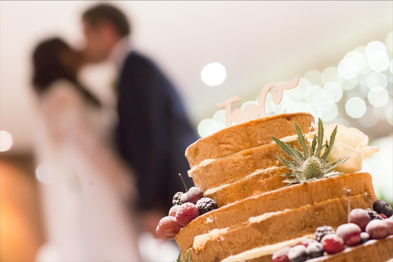 Wedding cake with blurred couple kissing