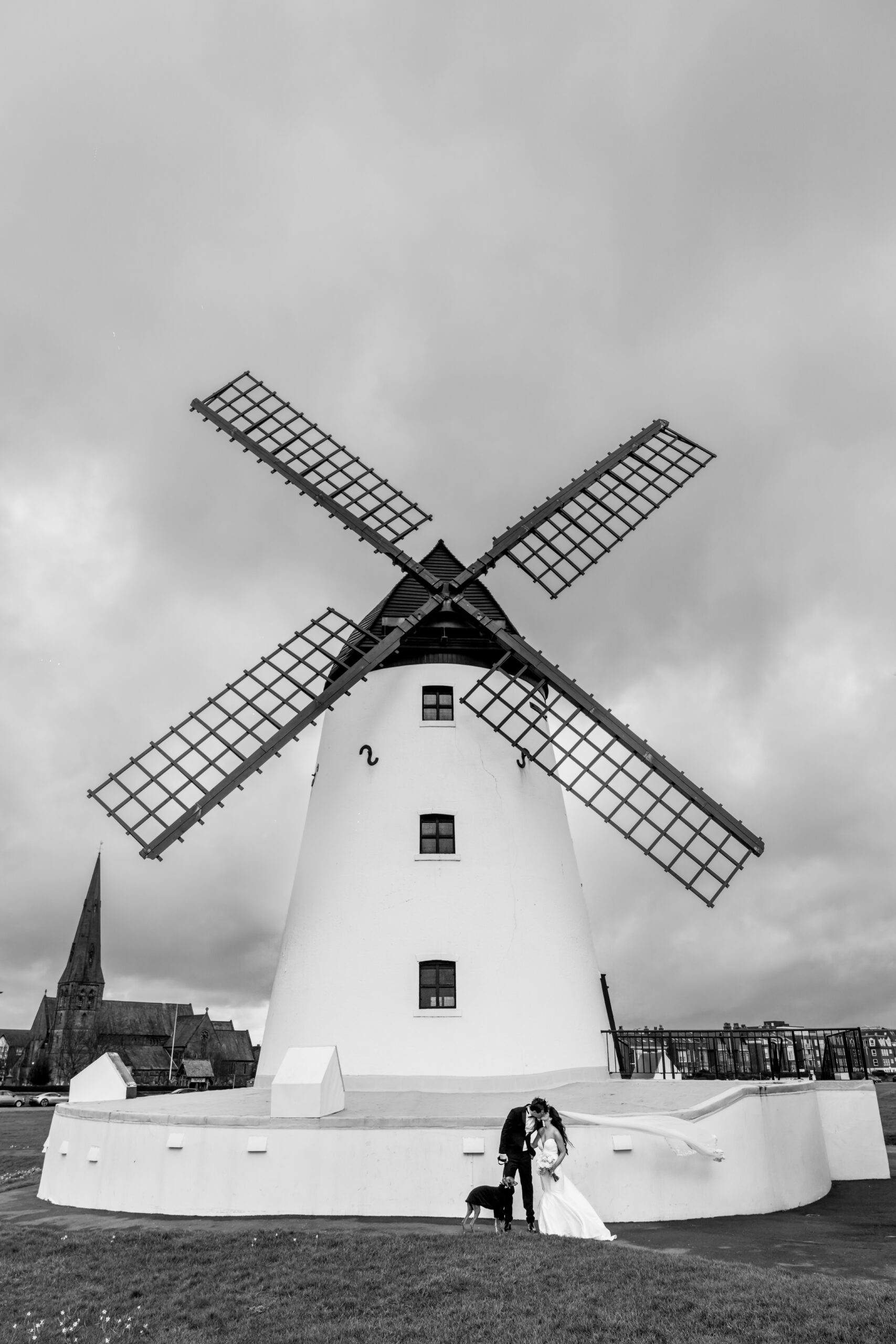 Bride and groom beneath large traditional windmill