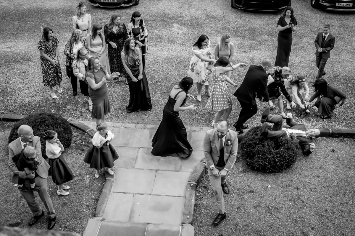 Group laughing at wedding reception scene outside.