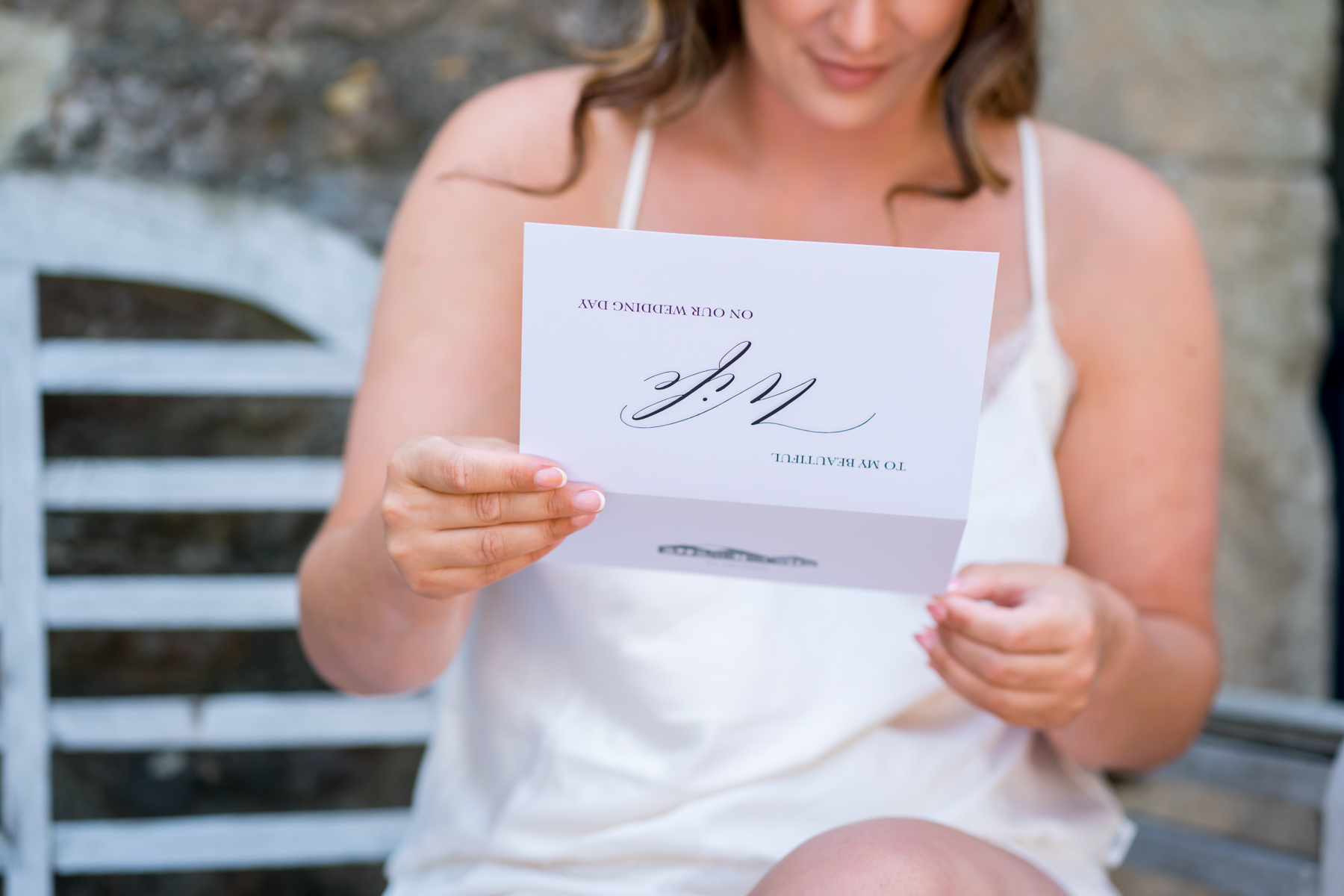 Bride reading wedding day card outdoors