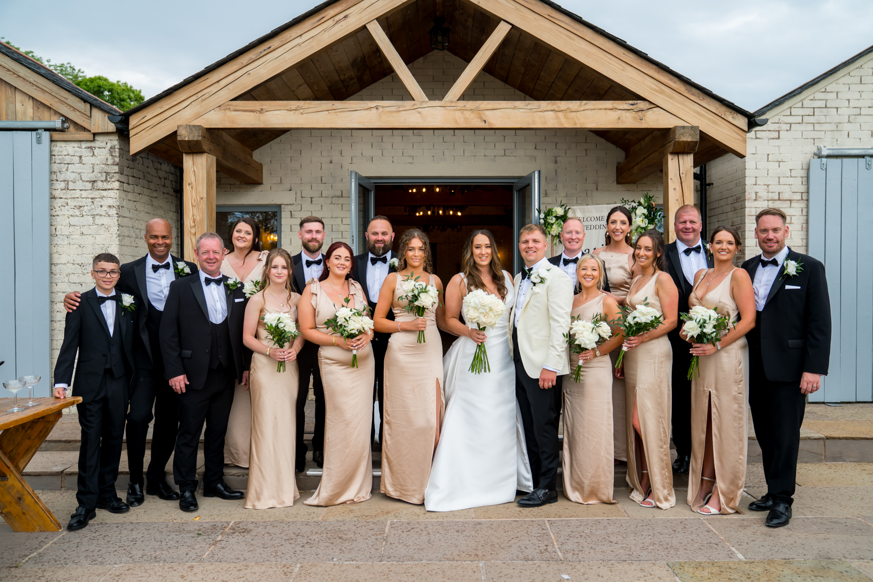 Wedding party posing outside rustic barn venue