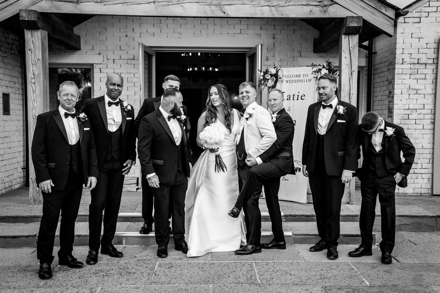 Bride with groomsmen outside wedding venue