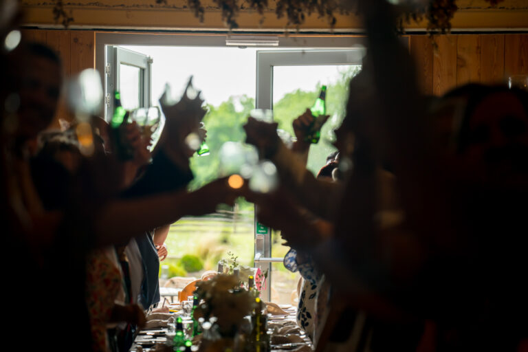 People raising glasses in a celebratory toast indoors