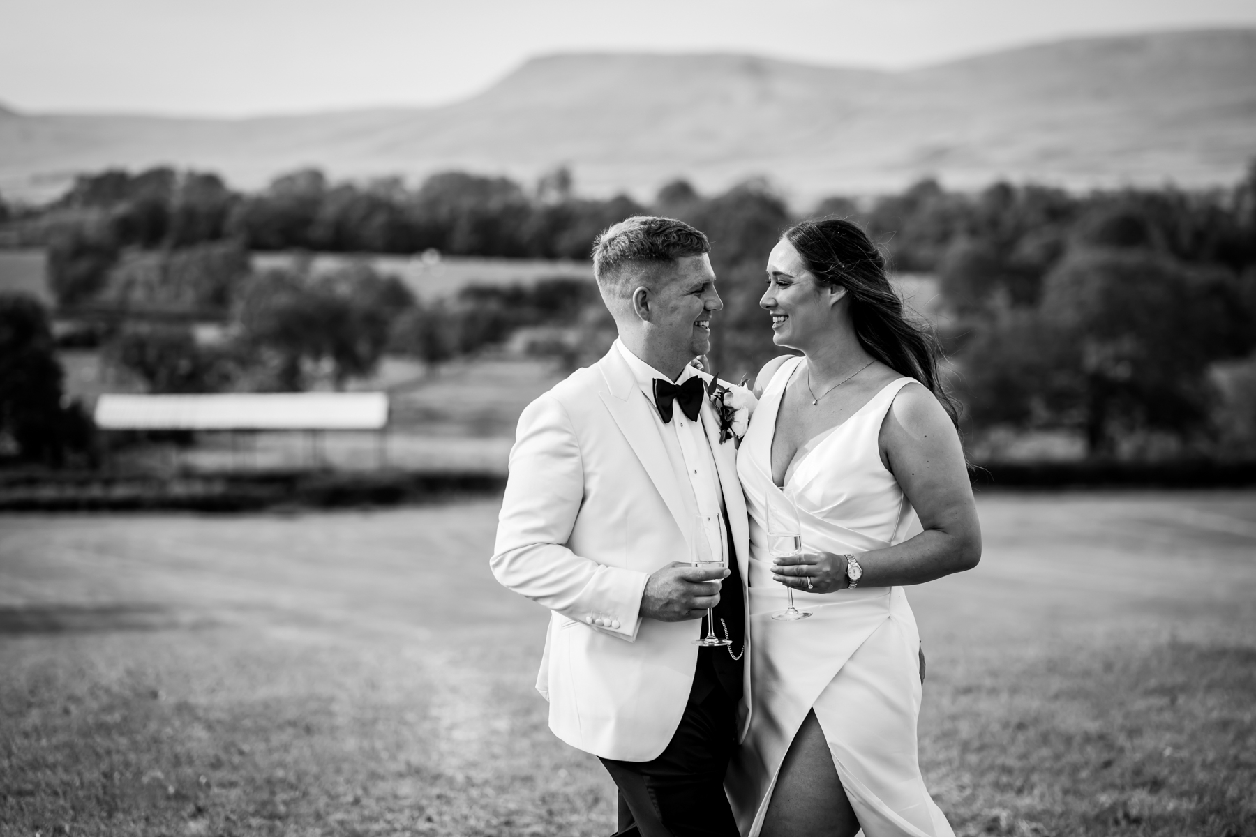 Bride and groom holding champagne outdoors