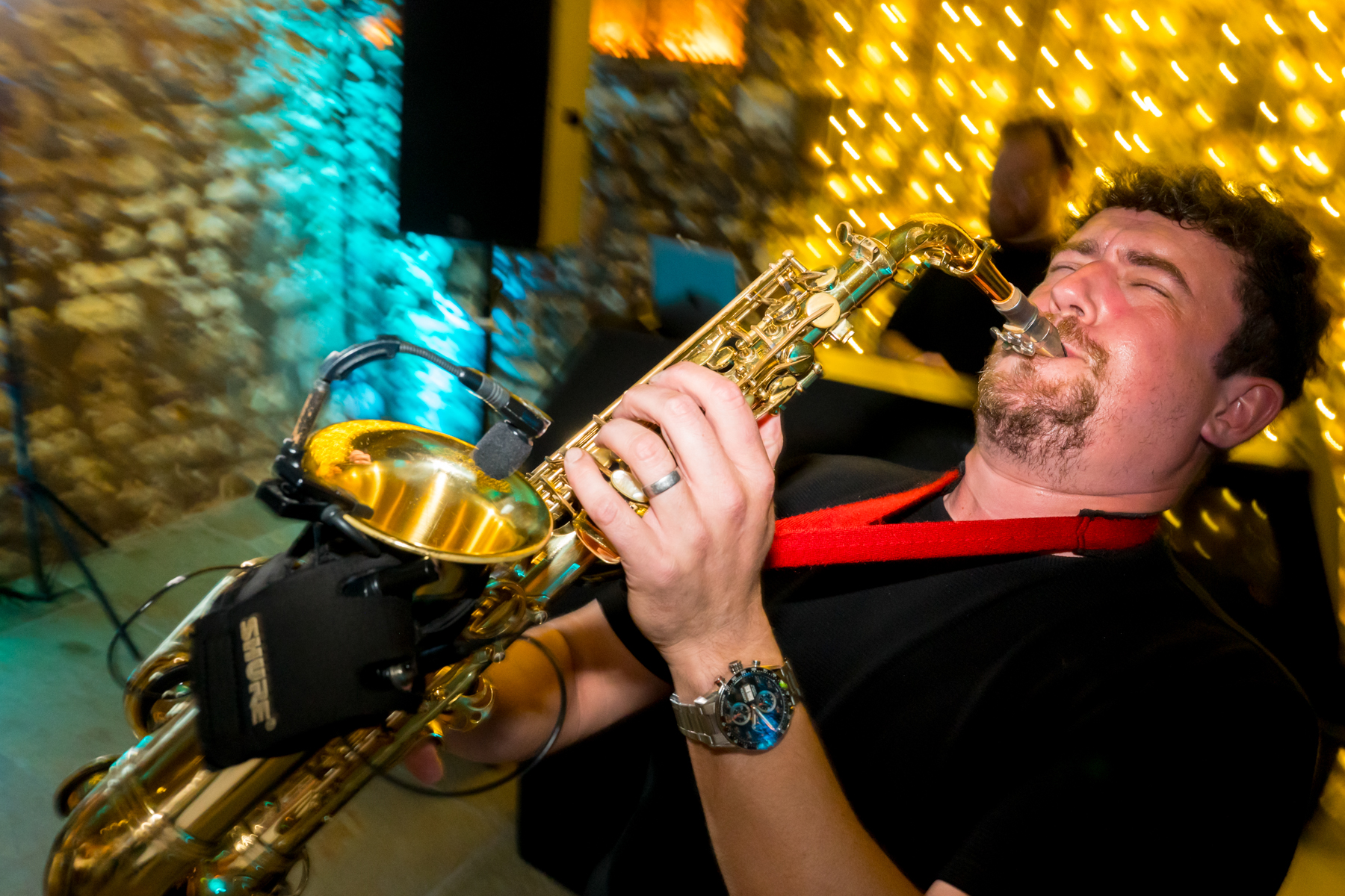 Man playing saxophone at festive indoor event