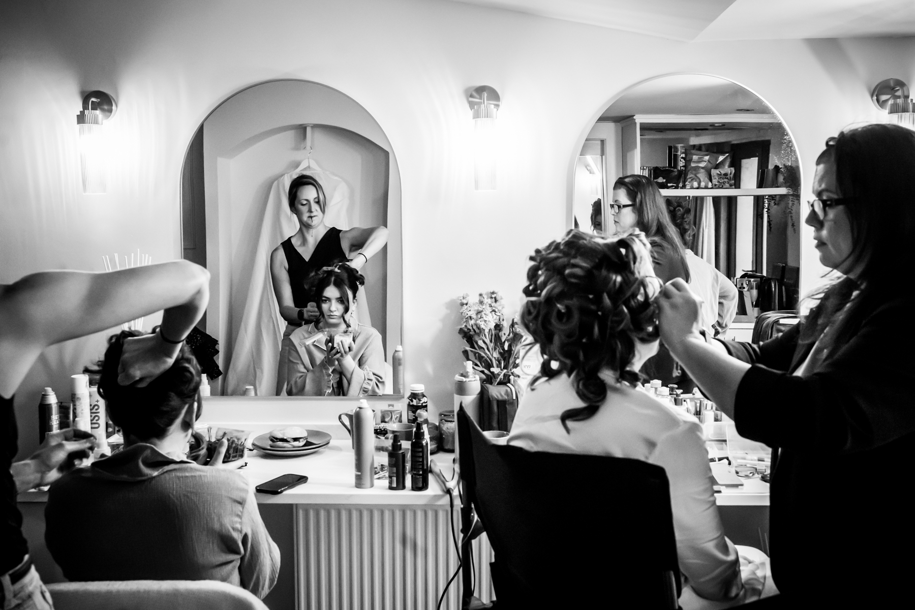Bride having hair styled before wedding ceremony