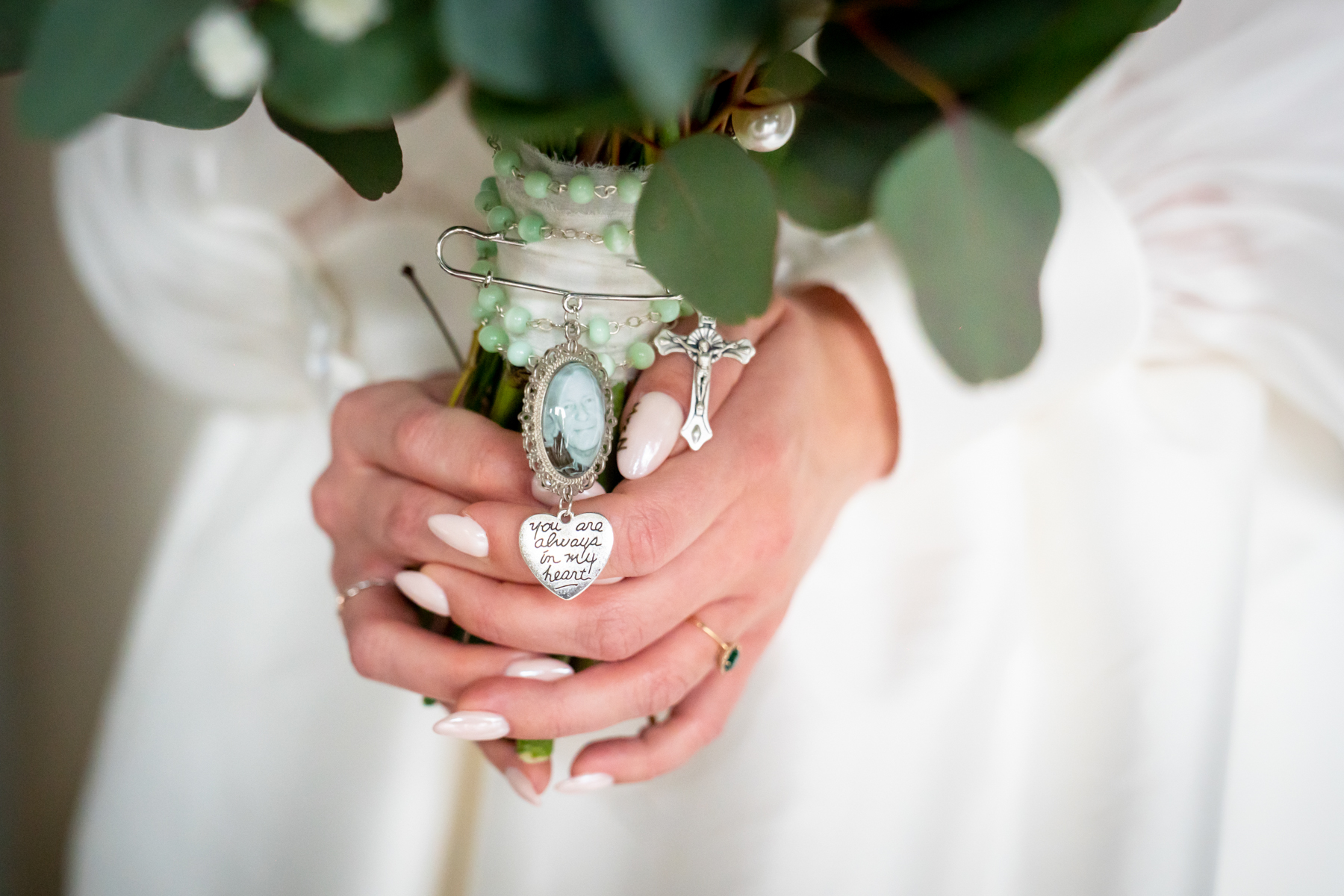Bride holding bouquet with rosary and photo locket
