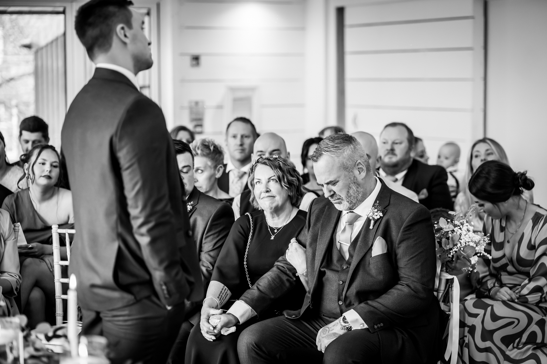 Emotional wedding guest holding hands during ceremony