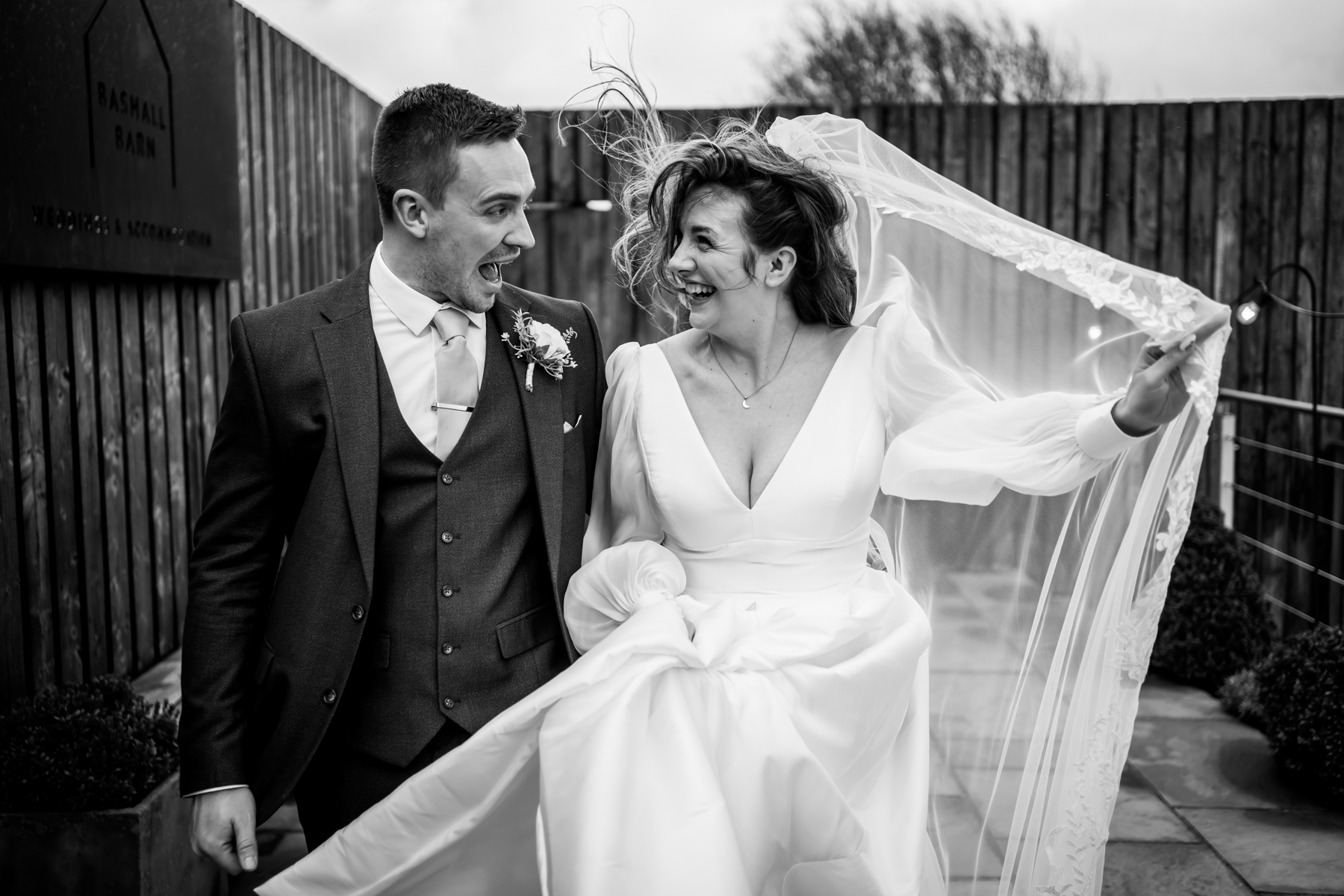 Bride and groom laughing in windy outdoor wedding