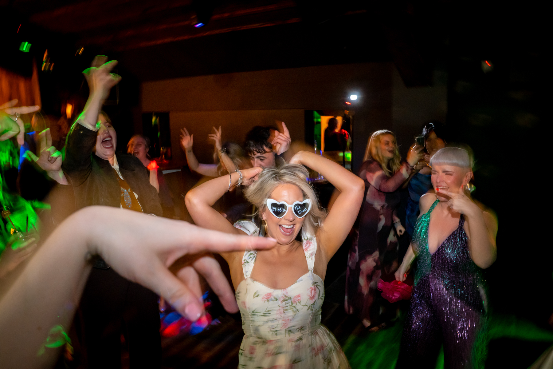 Guests dancing energetically at wedding reception party