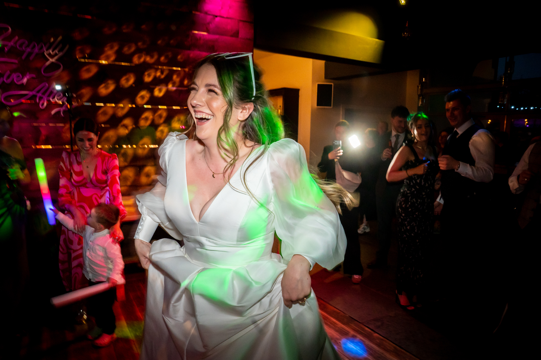 Bride dancing at colourful wedding reception party