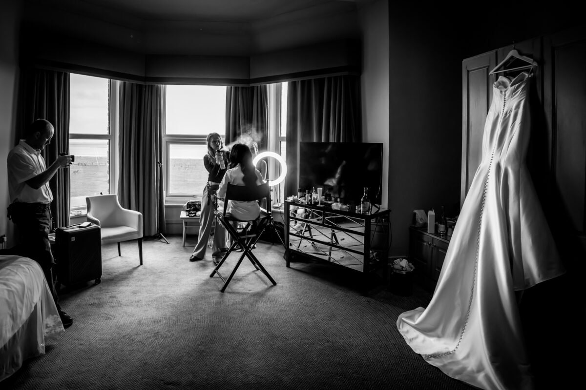 Bride having hair and makeup done in hotel room