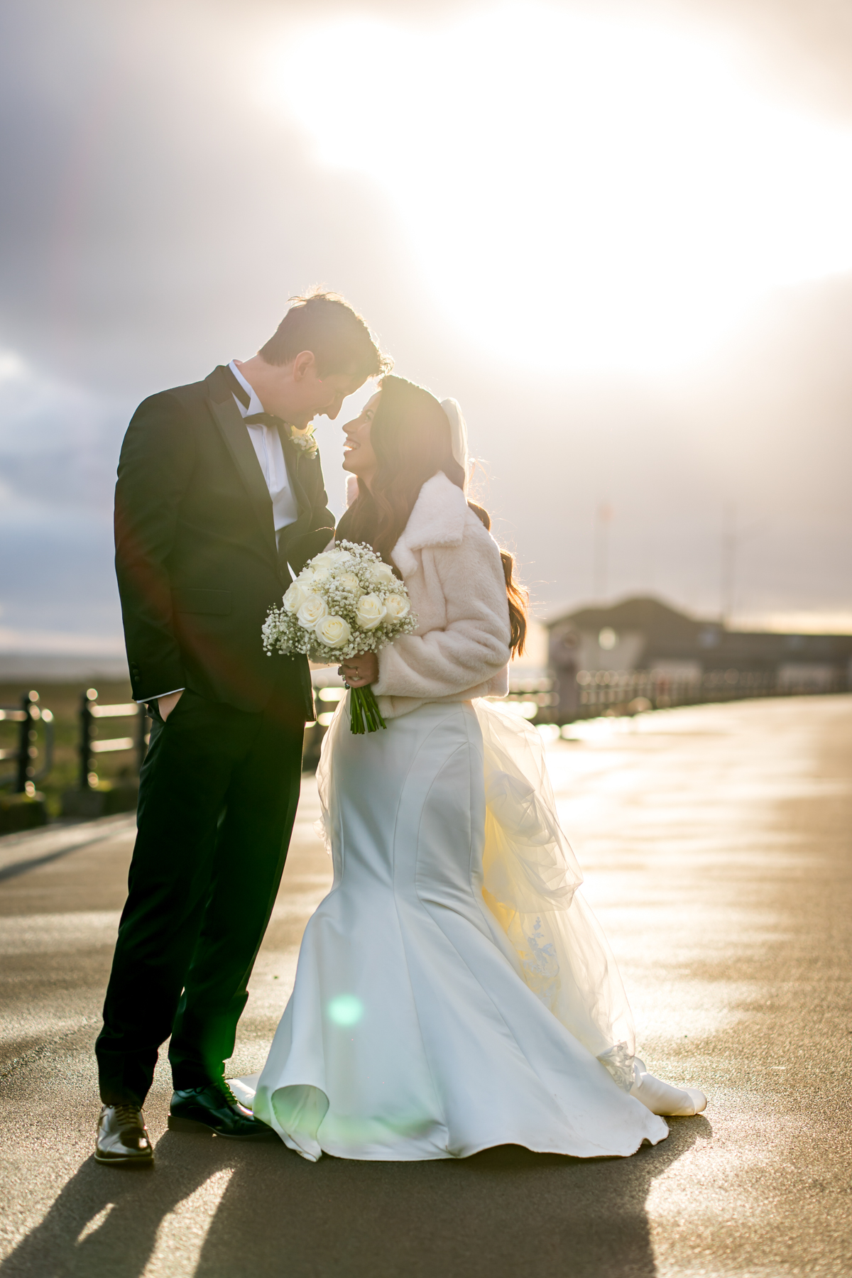 Bride and groom embracing at sunset outdoors