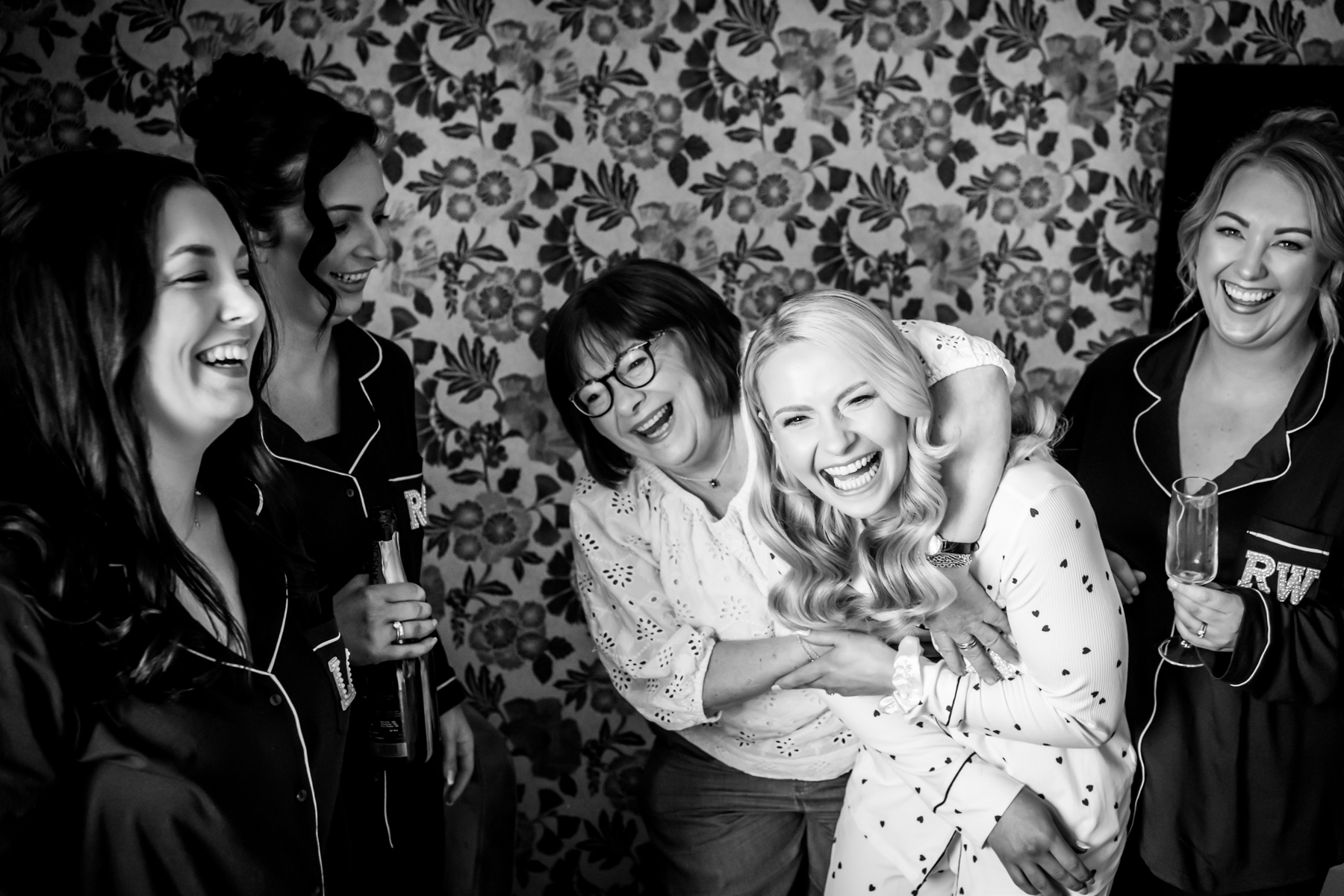 Five women laughing together in matching pyjamas