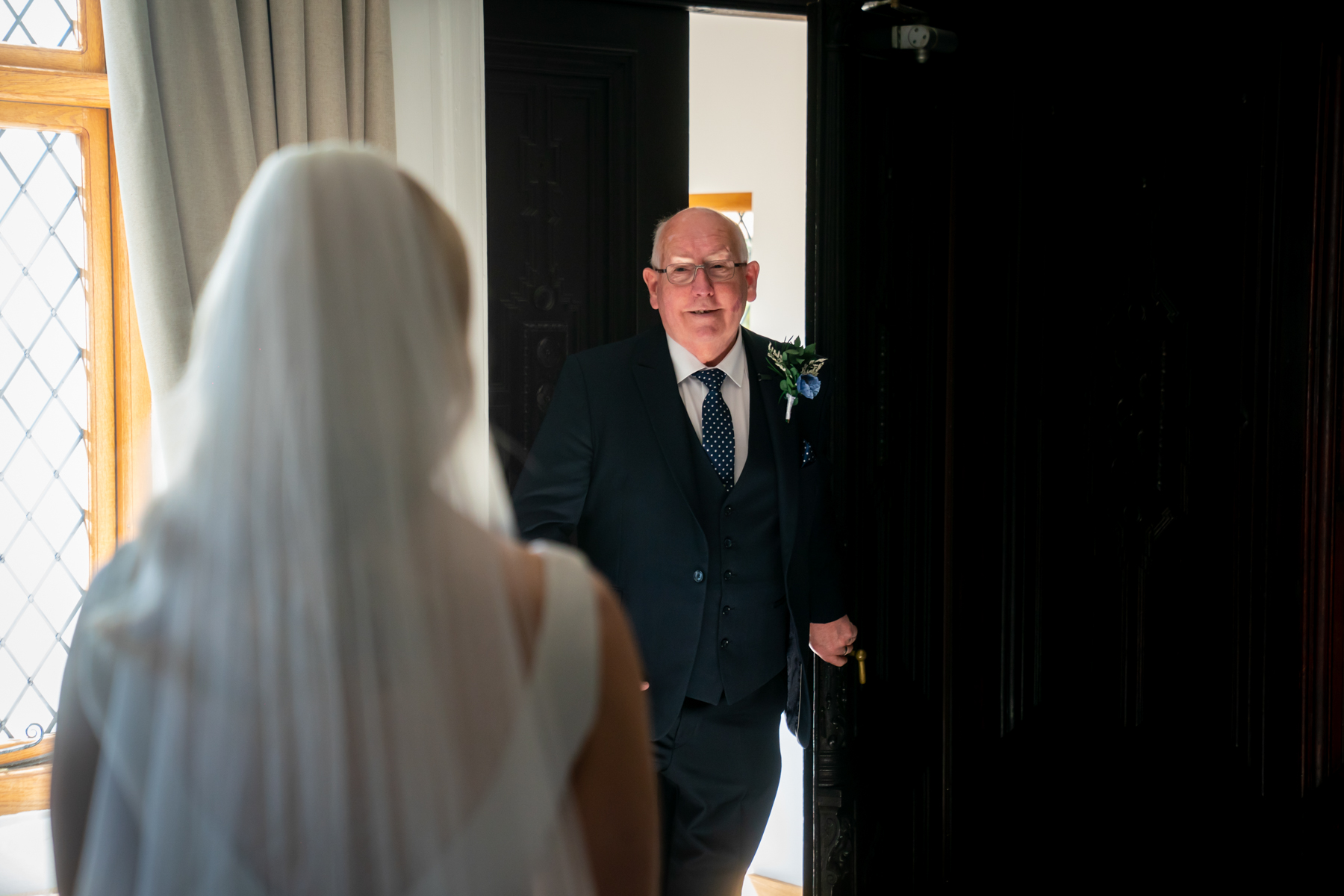 Bride shares first look with father indoors