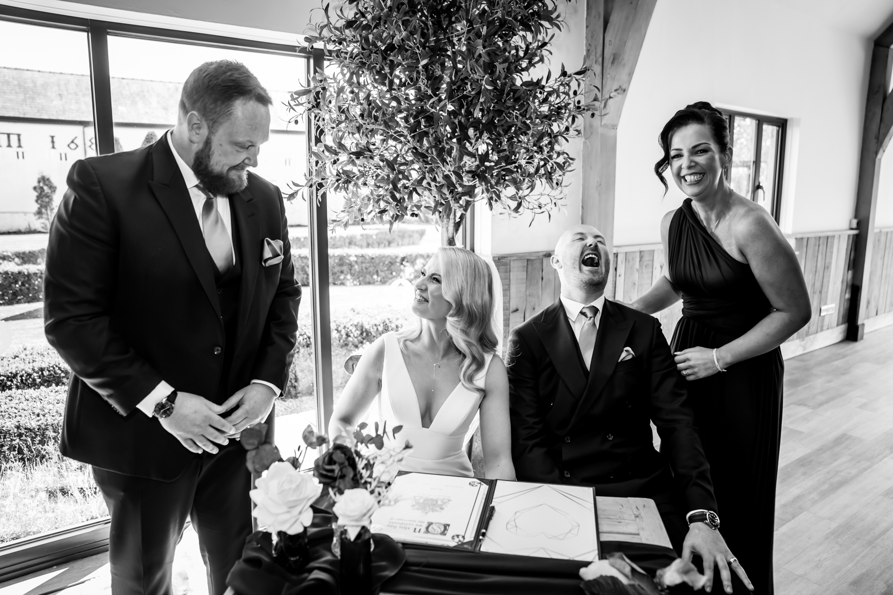 Bride and groom laughing during wedding register signing