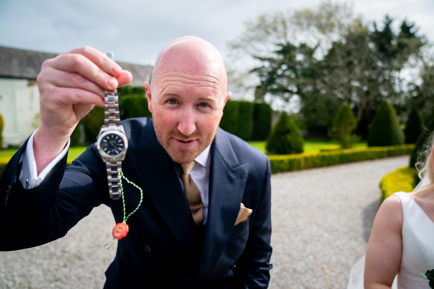 Man in suit holding wristwatch outdoors