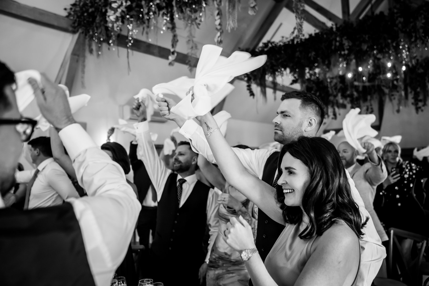 Wedding guests waving napkins at reception celebration