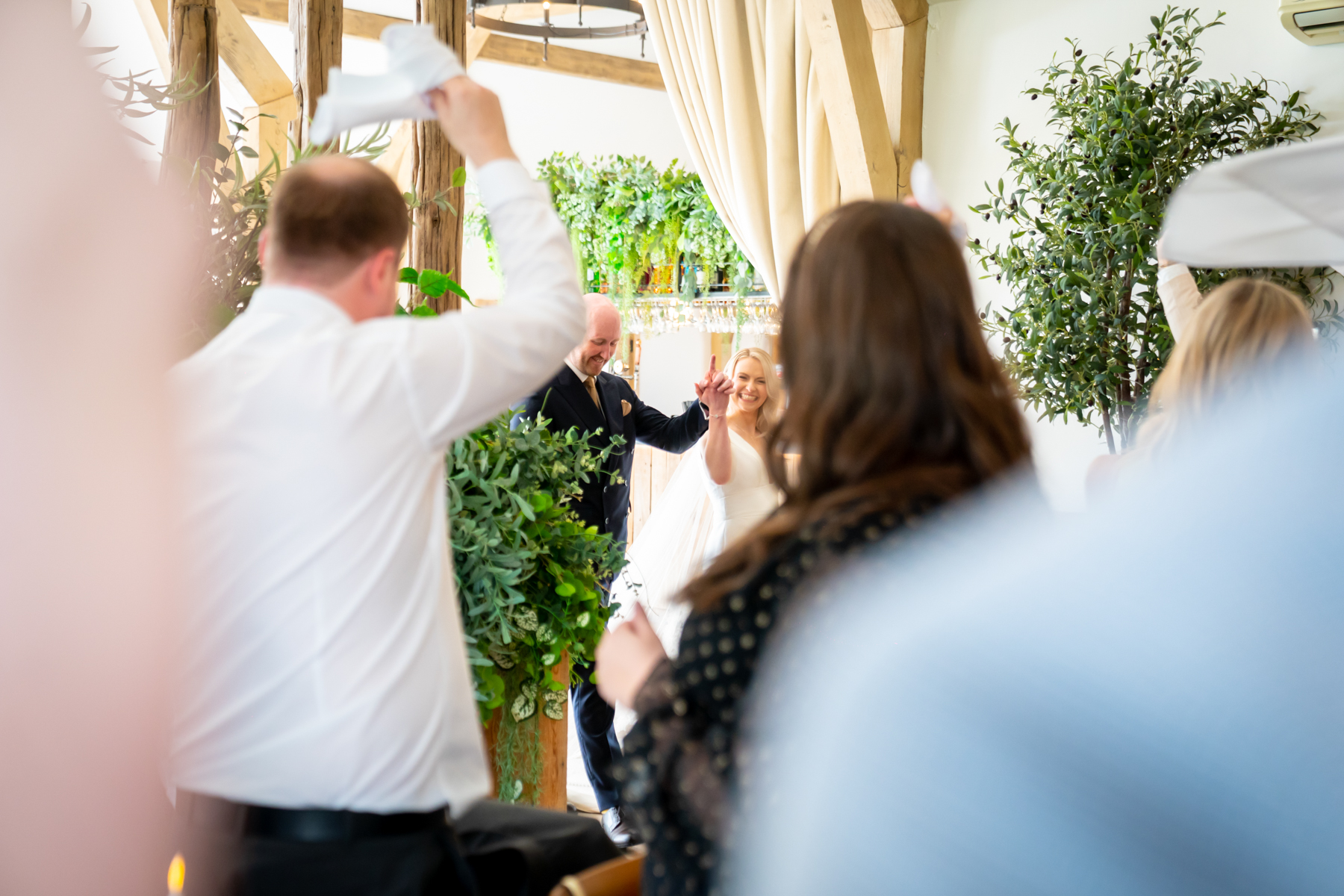 Bride and groom entering rustic indoor wedding ceremony