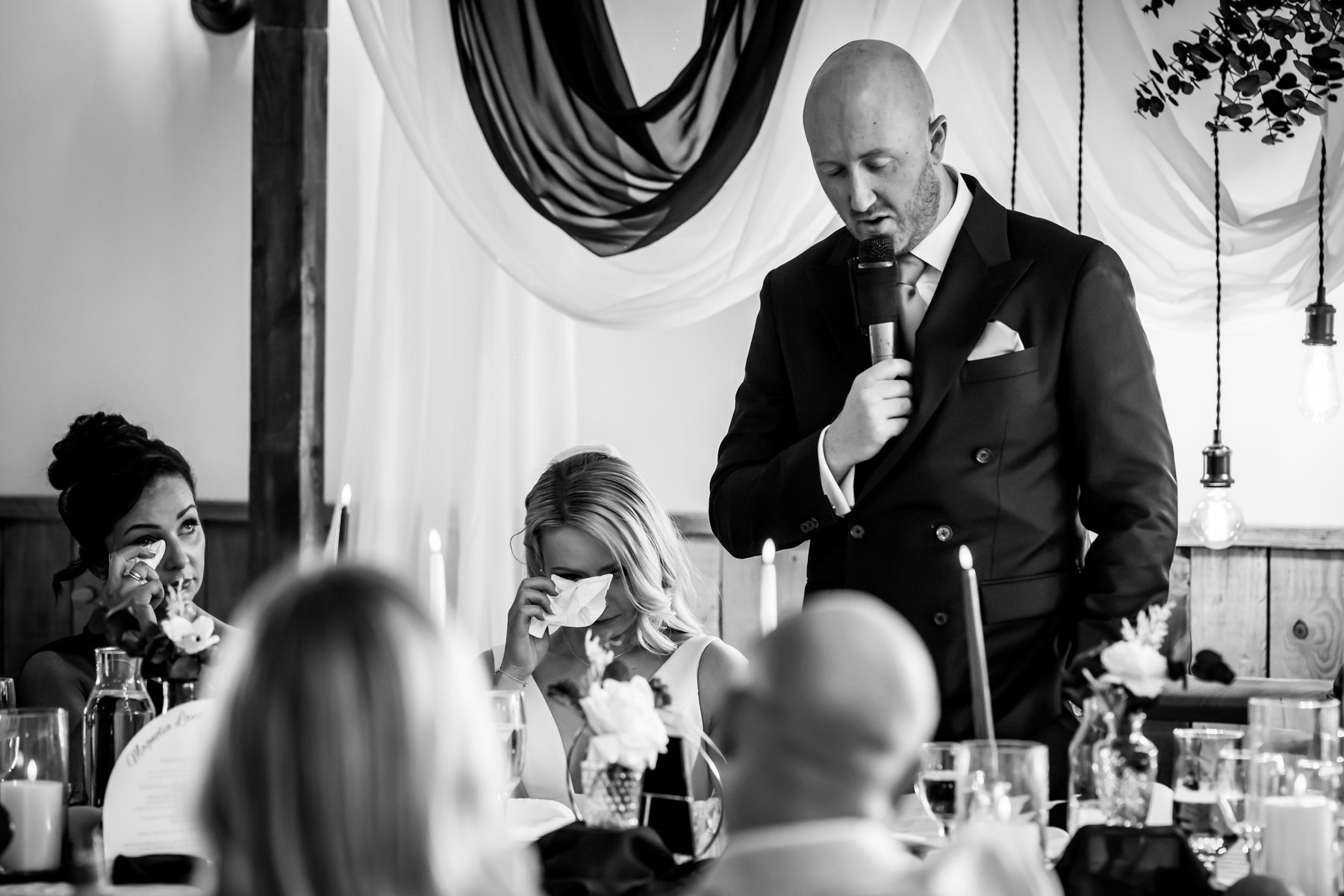 Man giving emotional wedding speech to tearful bride