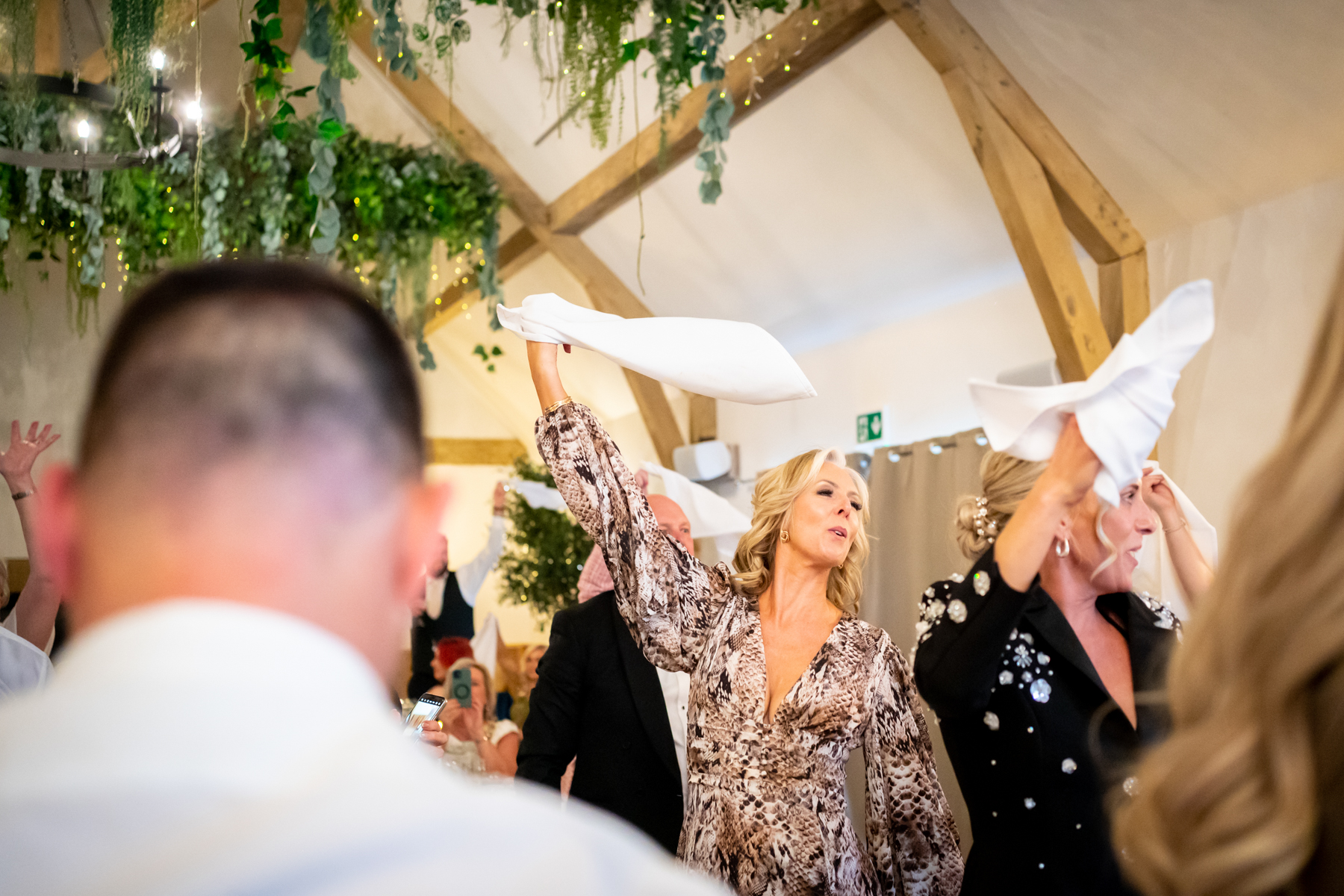 Guests waving napkins at lively wedding reception