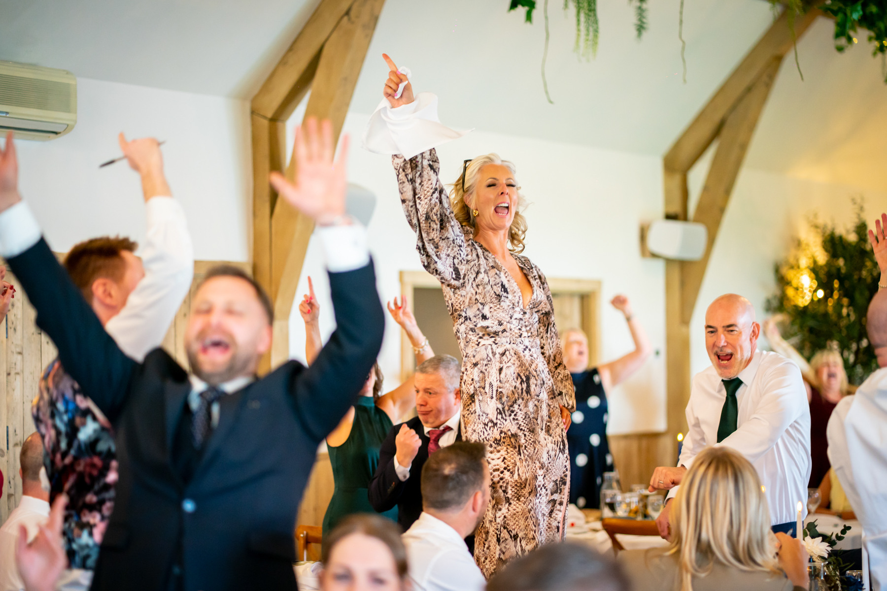 Woman cheering on table at wedding reception