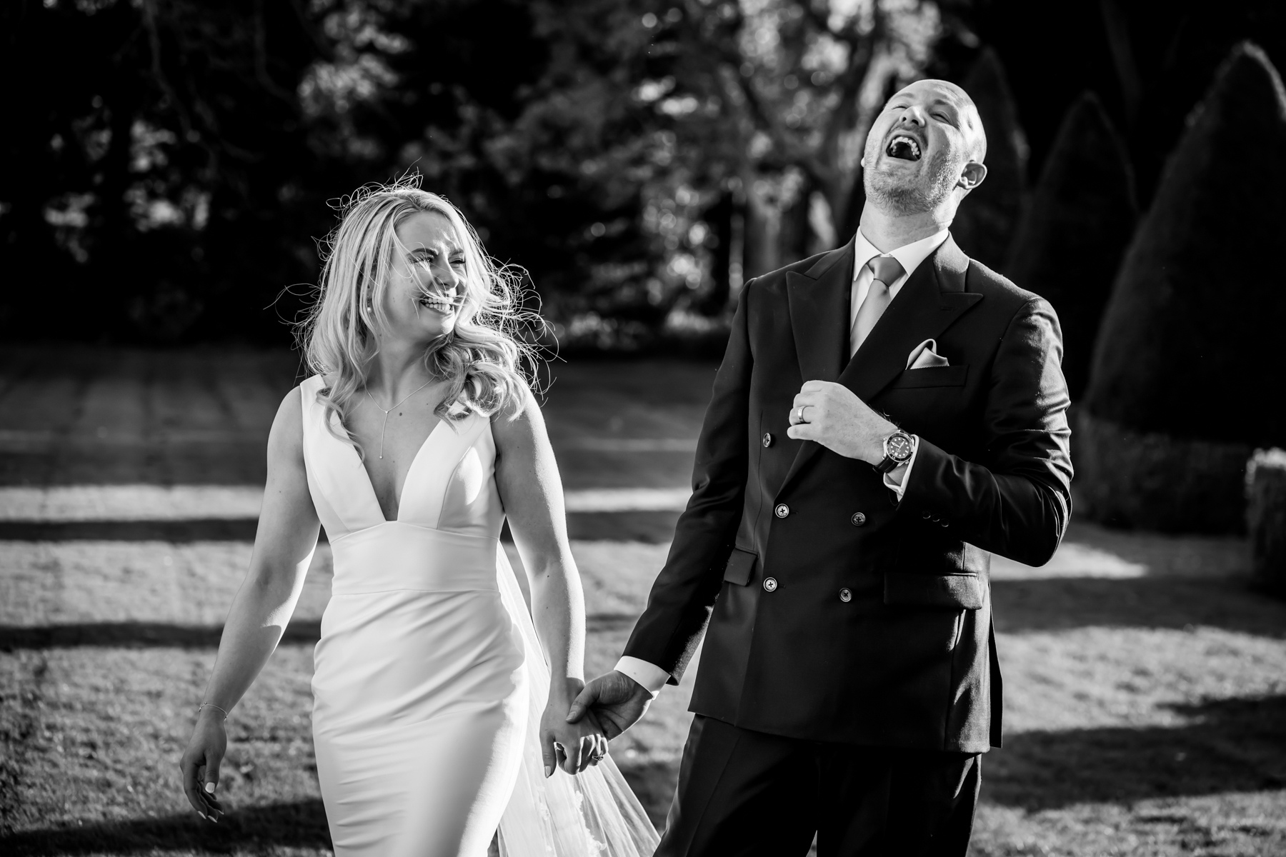 Bride and groom laughing outdoors on wedding day