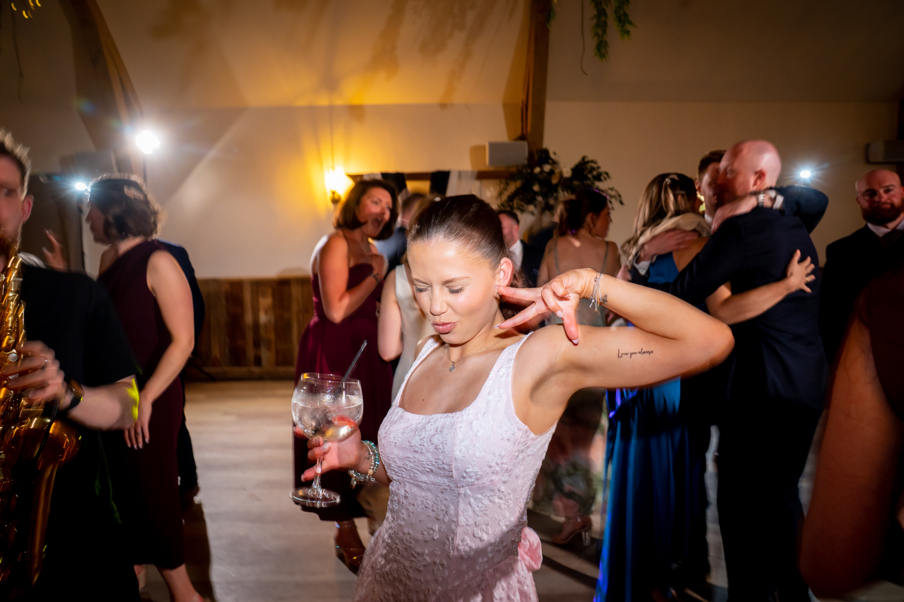Woman dancing with drink at wedding reception